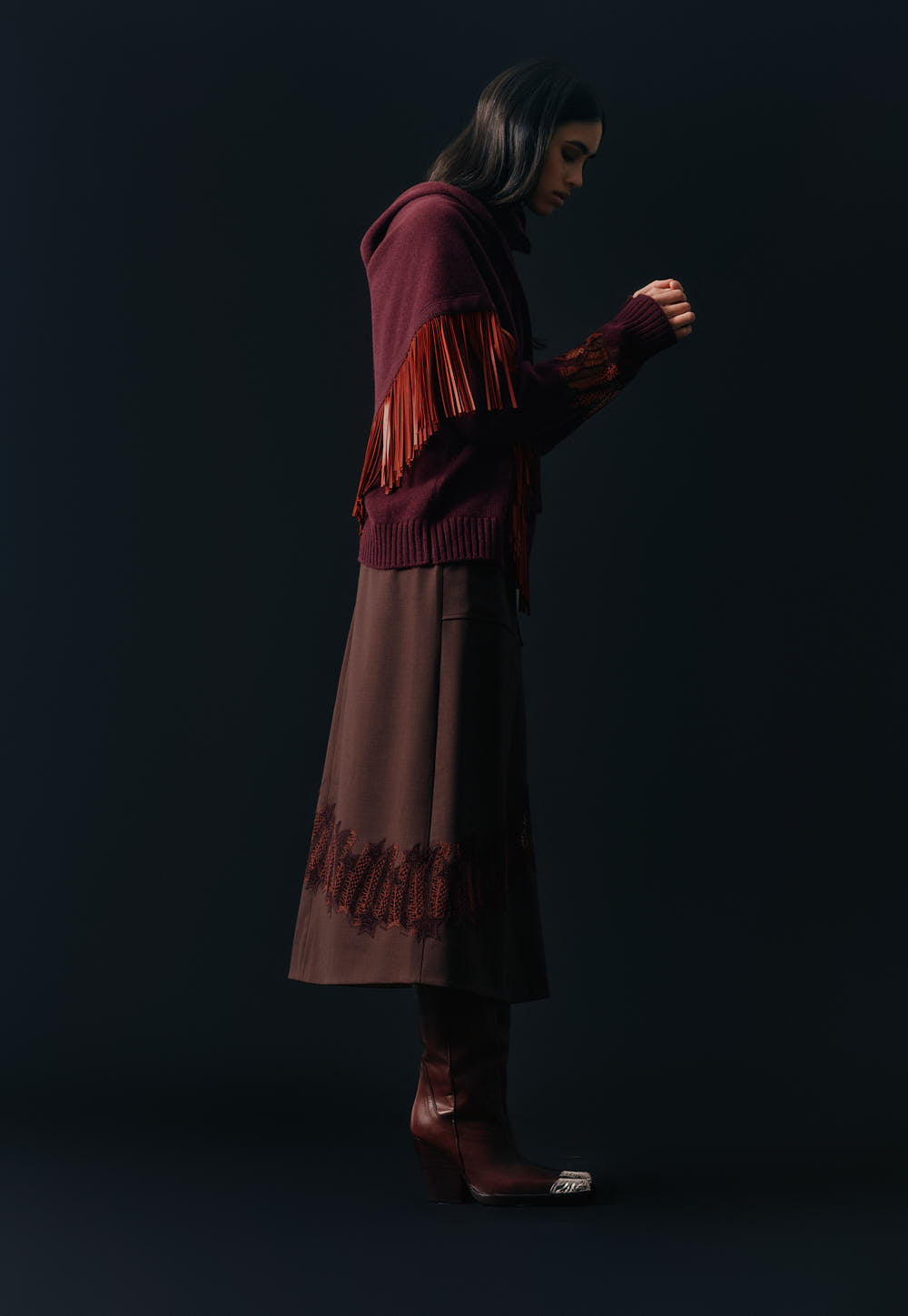 Side view of the Antonia Zander Romina Skirt in bordeaux styled with cashmere knitwear.